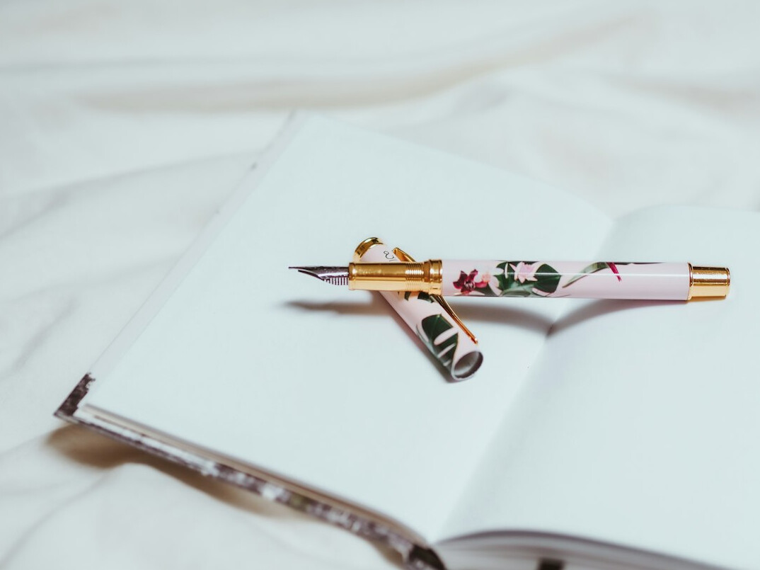 Open notebook with handwritten notes and a fountain pen